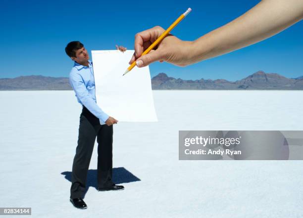 giant hand writing on pad held by man - forced perspective stock pictures, royalty-free photos & images