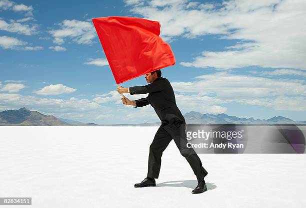 businessman waving red flag on salt flat - red flag warning stock pictures, royalty-free photos & images