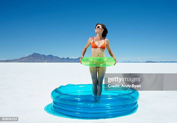 woman standing in pool in desert - planschbecken stock-fotos und bilder