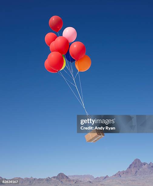 balloons carrying box across sky - balloon sky stock pictures, royalty-free photos & images