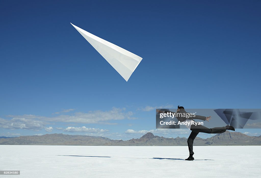 Businessman Throwing Giant Paper Airplane.