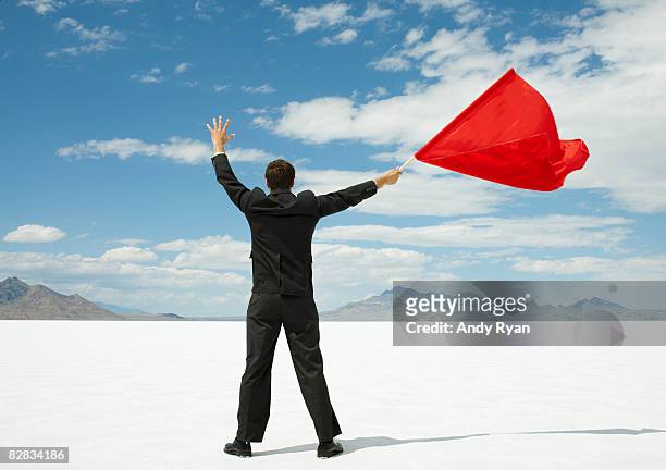 businessman waving red flag on salt flats. - holding flag stock pictures, royalty-free photos & images