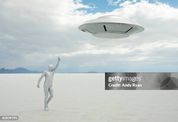 alien running after ufo. - sinnlosigkeit stock-fotos und bilder