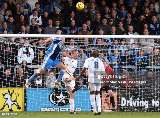 Wycombe's Tommy Mooney heads towards the Mansfield goal as Jon Olav Hjelde and Gus Uhlenbeed look on during the Coca-Cola League Two match at...