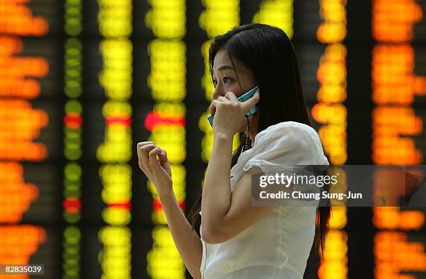 Woman looks at a board showing stock price index at a stock brokerage firm in Seoul September 16, 2008 in Seoul, South Korea. The Korean stock...