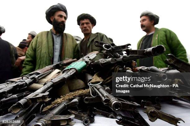 Members of former warlord General Rashid Dostum's militia hand over some of their arsenal to the Afghan National Army in Sherberghan, Northern...