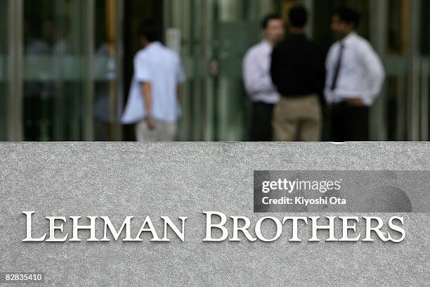 People stand outside the Tokyo branch of Lehman Brothers Holdings on September 16, 2008 in Tokyo, Japan. The Japanese market has plummeted following...