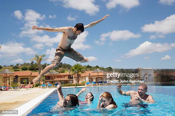 crazy man jumping on friends in swimming pool - seat perilous stock-fotos und bilder