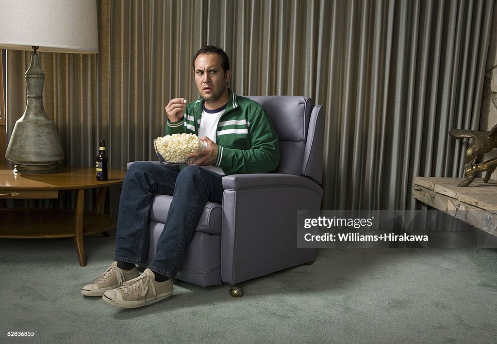 Man in chair eating popcorn