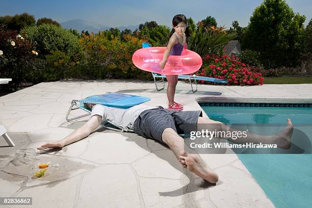 girl looking at man in collapsed deck chair - crollare foto e immagini stock