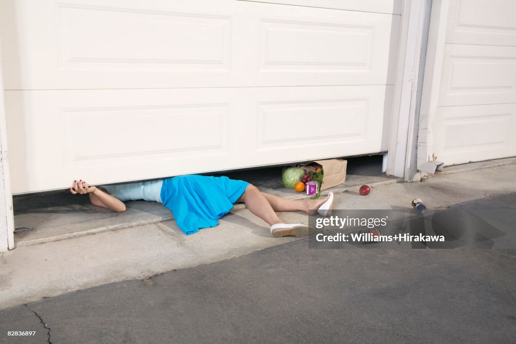 Woman trapped under garage door