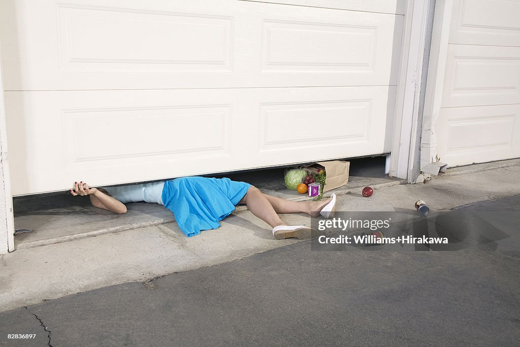 Woman trapped under garage door
