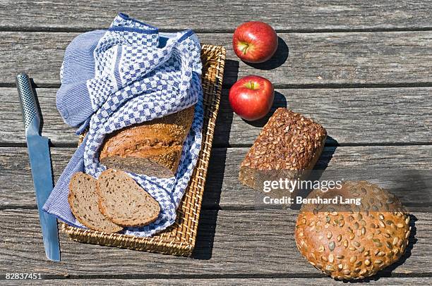 loaves of whole-grain bread and apples - bread knife stock-fotos und bilder