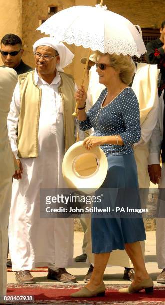 The Duchess of Cornwall takes shade under a parasole, in the western Egyptian desert town of Siwa, Thursday March 23, 2006. As temperatures hit the...