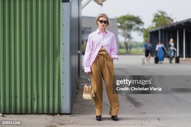 Annabel Rosendahl wearing high waisted brown pants, pink button shirt outside By Malene Birger on August 09, 2017 in Copenhagen, Denmark.