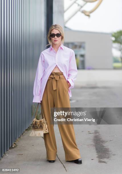 Annabel Rosendahl wearing high waisted brown pants, pink button shirt outside By Malene Birger on August 09, 2017 in Copenhagen, Denmark.