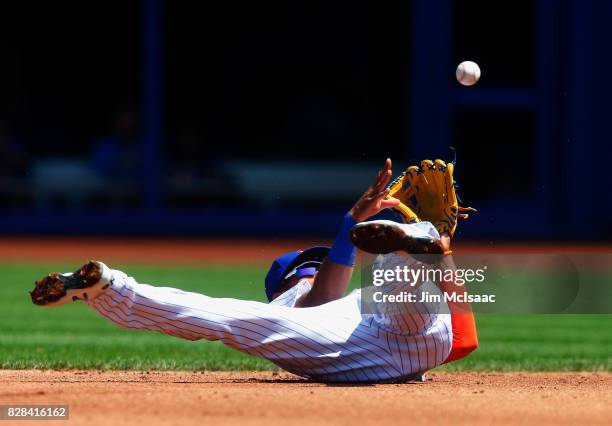 Amed Rosario of the New York Mets flips the ball to second base for an out against the Texas Rangers during the second inning at Citi Field on August...