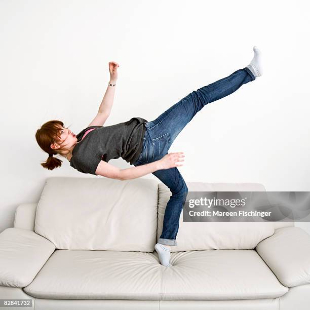 girl jumping on white leather couch - standing on one leg fotografías e imágenes de stock