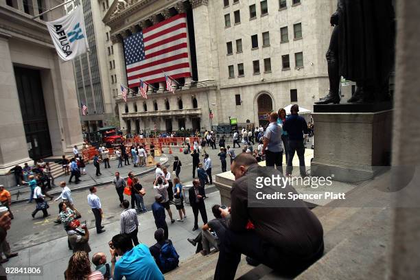 People sit on steps outside of the New York Stock Exchange September 16, 2008 in New York City. U.S. Stocks continued to drop Tuesday morning for the...