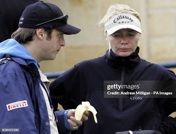 Model Jodie Kidd watches her husband Aidan Butler eat a banana during the second round of the Dunhill Links Championships at St Andrews Golf Course,...