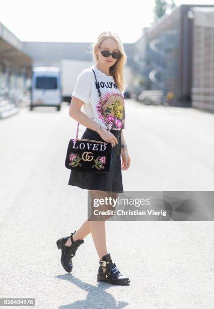 Juliane Diesner wearing Gucci bag with Loved print, white printed tshirt, mini skirt, Balenciaga boots outside By Malene Birger on August 09, 2017 in...