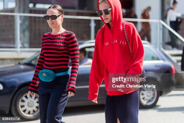 Guest wearing a Gucci velvet belt bag and a guest wearing a red hoody outside By Malene Birger on August 09, 2017 in Copenhagen, Denmark.