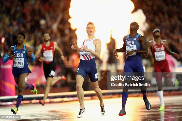 Karsten Warholm of Norway crosses the finishline to win gold in the Men's 400 metres hurdles final ahead of Kerron Clement of the United States...