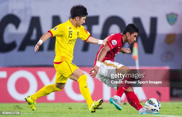 Kashiwa Reysol midfielder Taketomi Kosuke fights for the ball with Guangzhou Evergrande midfielder Bezerra Maciel Junior during the Guangzhou...