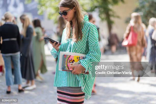 Guest wearing a green white striped button shirt outside Munthe on August 09, 2017 in Copenhagen, Denmark.