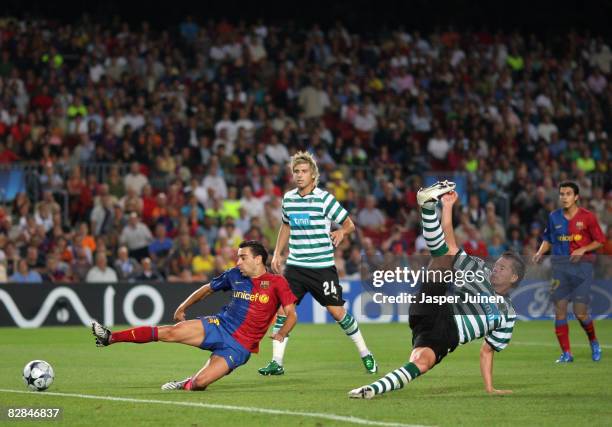 Xavi Hernandez of Barcelona scores his team's third goal past Anderson Polga and Miguel Veloso of Sporting Lisbon during the UEFA Champions League...