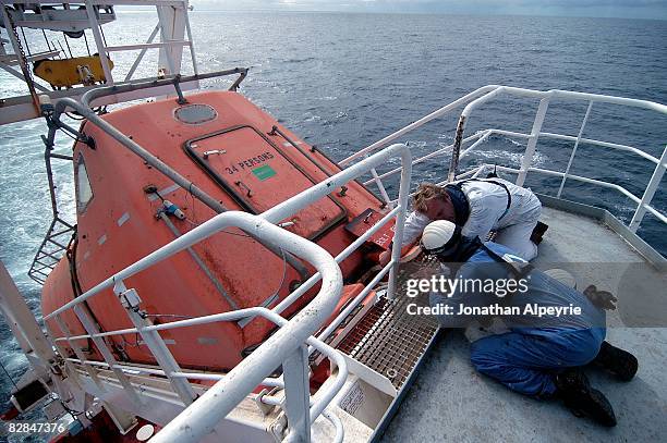 One of the Dutch officers is showing how the emergency boat works to one of the Filipino seaman, on July 20 in France. If the tanker sinks all crew...