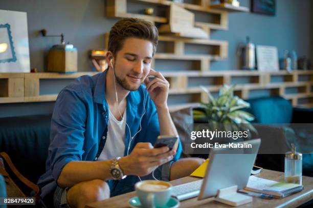 hombre joven de trabajar en oficina en casa - autonomo smartphone tablet fotografías e imágenes de stock