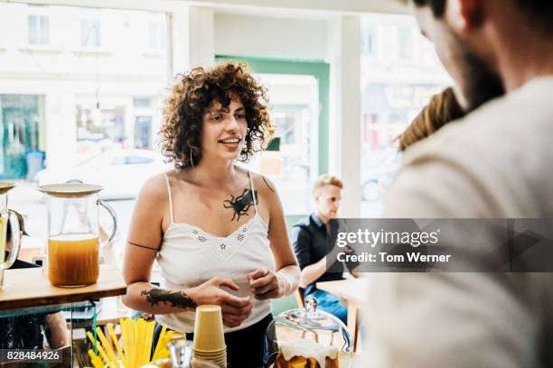 a woman ordering something to eat from counter at coffee shop - baloch culture stock pictures, royalty-free photos & images