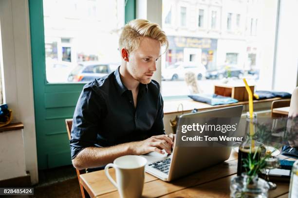 young man working on laptop in cafe - initiative stock pictures, royalty-free photos & images