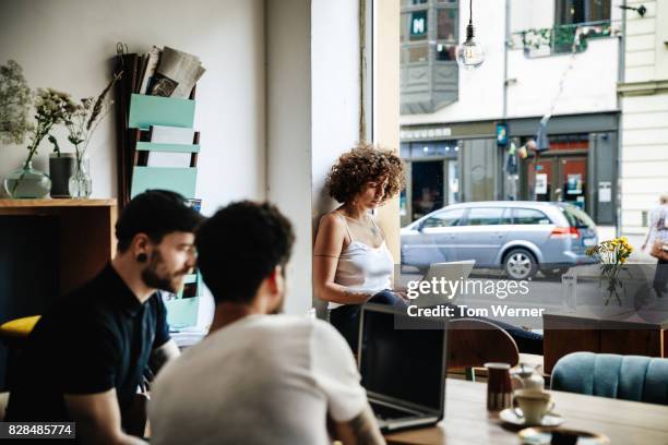 young woman working quietly in cafe - café stockfoto's en -beelden