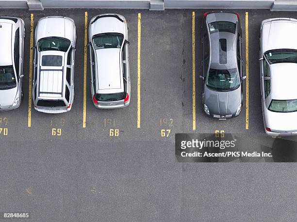 overhead view of cars in parking lot, one empty  - linea gialla foto e immagini stock