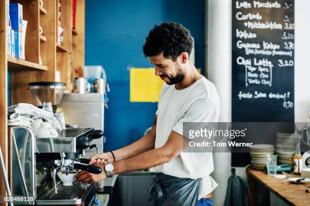 barista making coffee for customers at cafe - barista foto e immagini stock