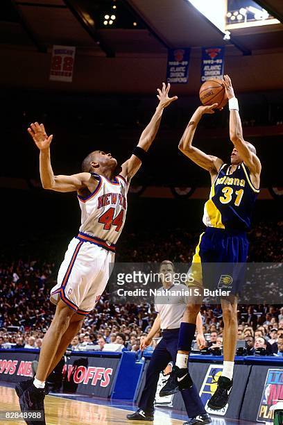 Reggie Miller of the Indiana Pacers shoots against Hubert Davis of the New York Knicks in Game Two of the 1995 Eastern Conference Semifinals played...