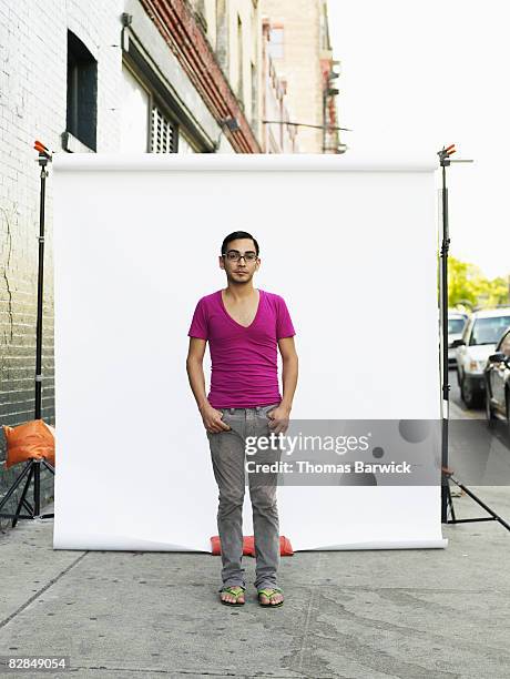 man on standing on sidewalk, portrait - backdrop photos et images de collection