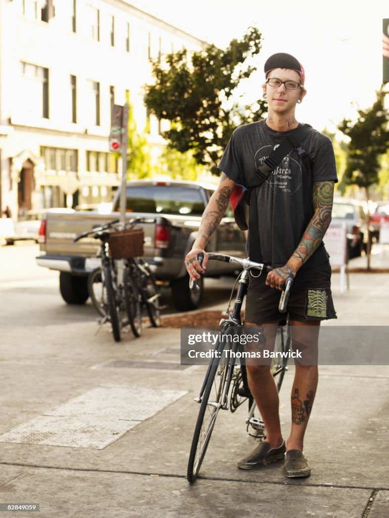 Man standing on sidewalk with bike