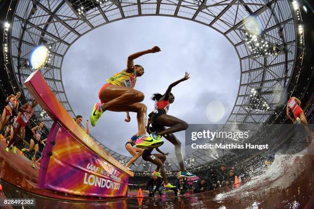 Sofia Assefa of Ethiopia and Hyvin Kiyeng Jepkemoi of Kenya take the hurdle at water jump as they compete in the Women's 3000 metres Steeplechase...