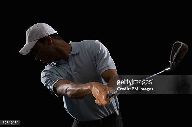 young man swinging golf club - golf swing foto e immagini stock