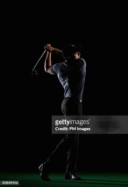 young man swinging golf club - golfer stock pictures, royalty-free photos & images