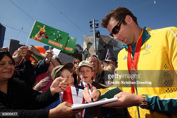 Swimmer Grant Hackett signs autographs for fans during a welcome home parade for the Beijing 2008 Olympic Athletes at Federation Square on September...