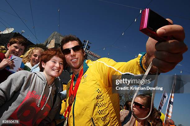 Swimmer Grant Hackett poses with a fan during a welcome home parade for the Beijing 2008 Olympic Athletes at Federation Square on September 17, 2008...