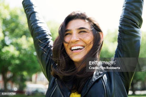 happy woman with arms in the air - brown hair stock pictures, royalty-free photos & images