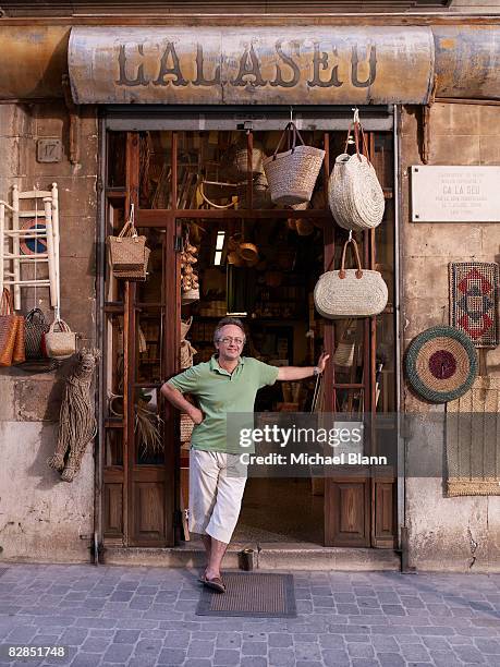 shop owner stands outside his shop - palma de mallorca spanje stockfoto's en -beelden
