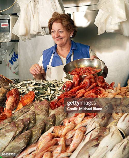 woman sells fish at stand - fish market stock pictures, royalty-free photos & images