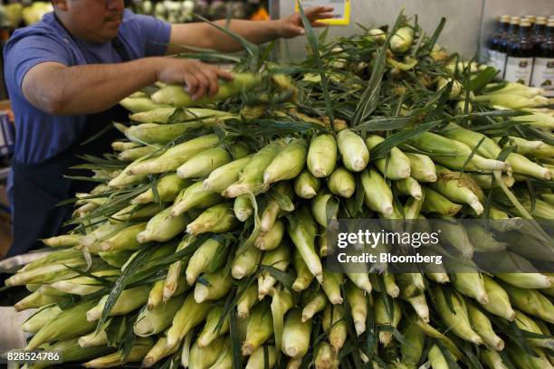 An employee stocks fresh corn during the grand opening of a Whole Foods Market 365 location in Santa Monica, California, U.S., on Wednesday, Aug. 9,...