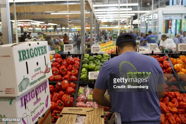 An employee stocks produce during the grand opening of a Whole Foods Market 365 location in Santa Monica, California, U.S., on Wednesday, Aug. 9,...